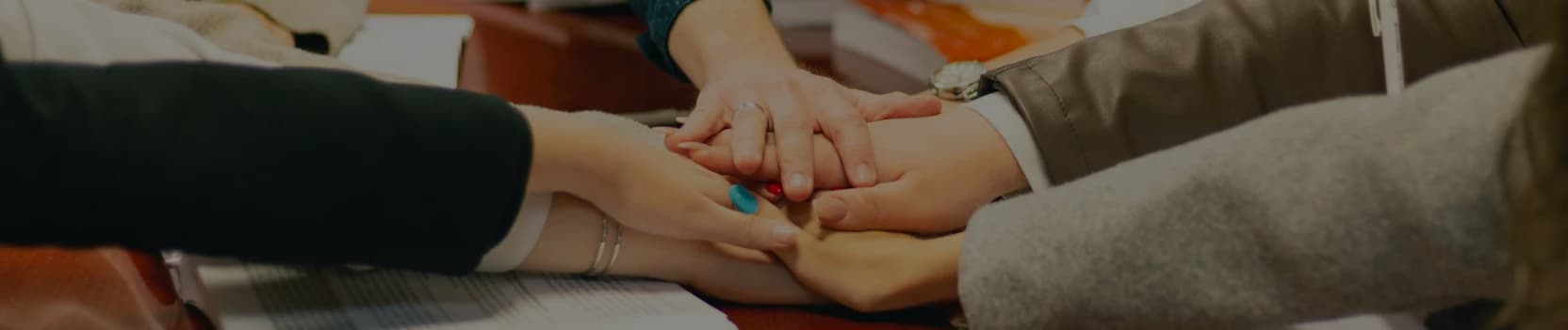 Hands joined in a supportive group session